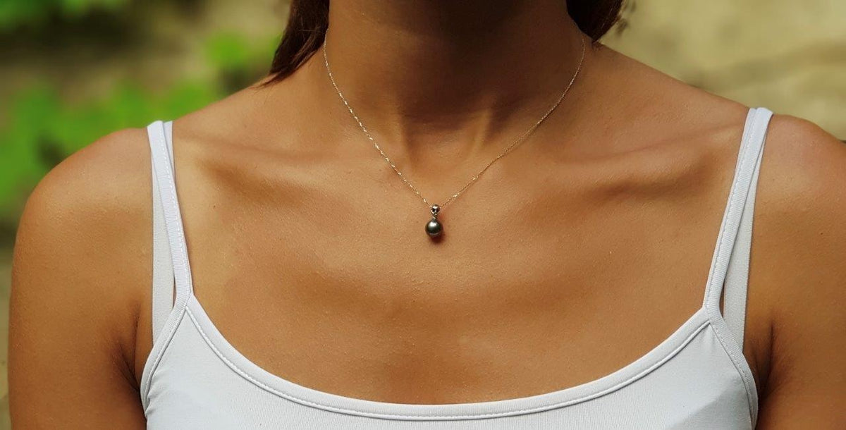 Pendentif perle noire et tête de mort liées