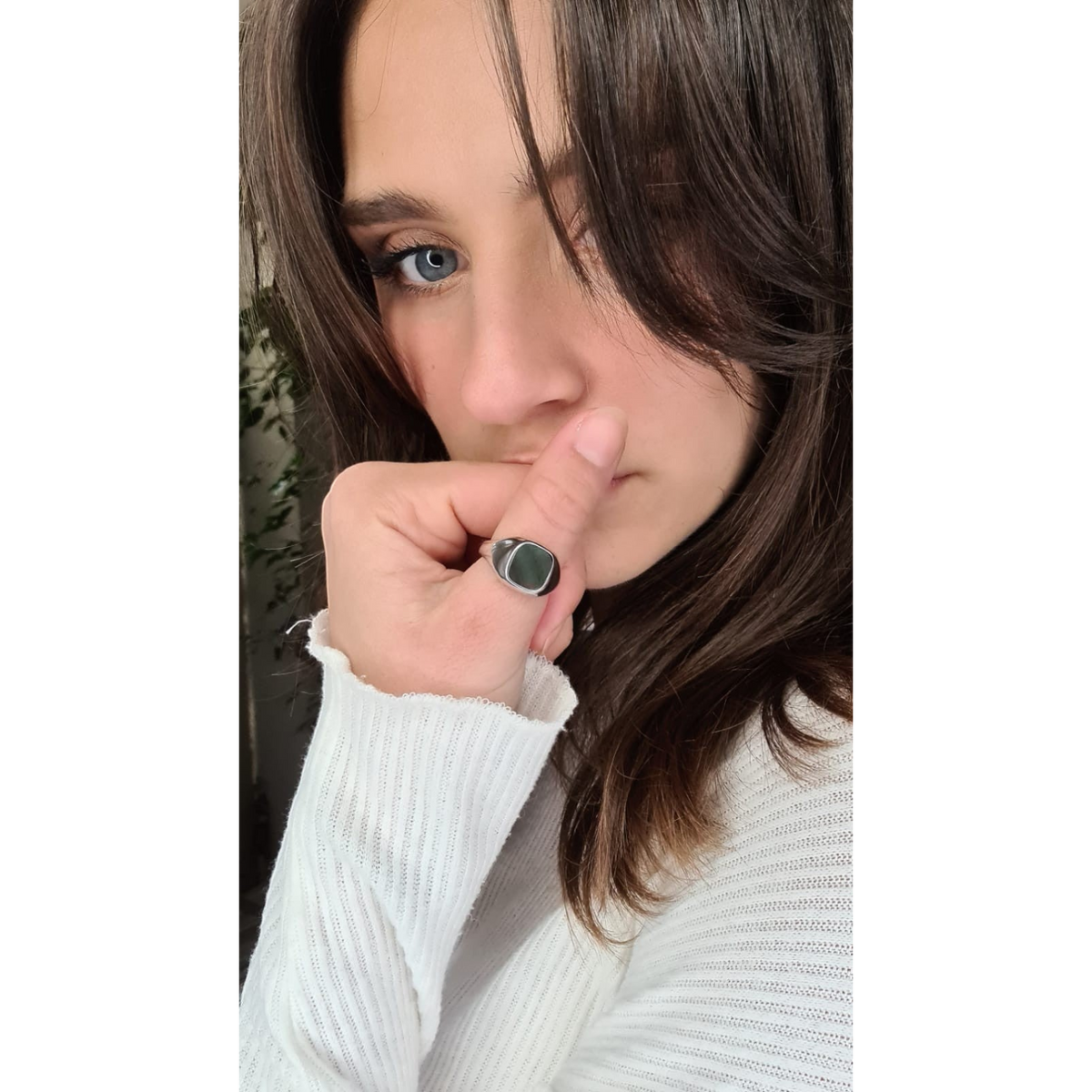 Bague chevalière Claverin Boyfriend en argent 925 et nacre grise portée par une femme en pull blanc