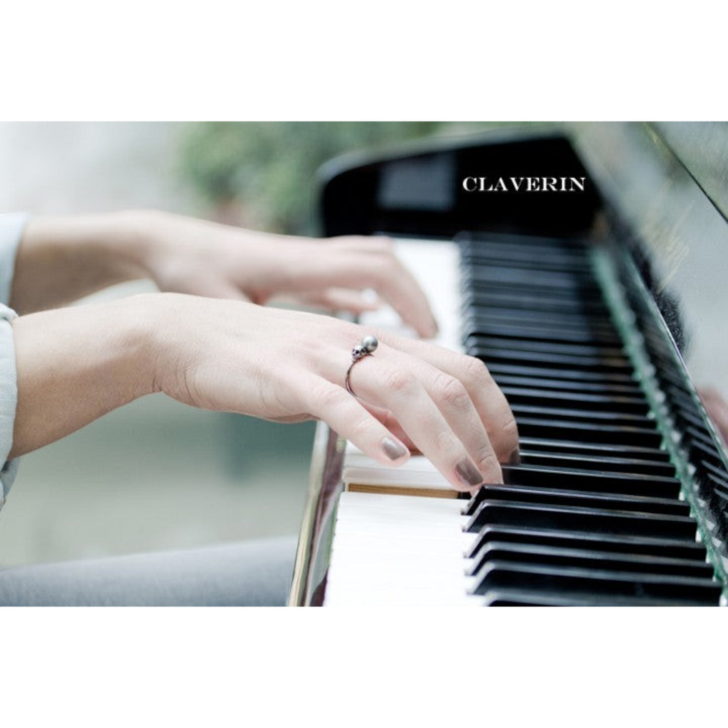 Bague Claverin avec perle noire de Tahiti et tête de mort en or blanc portée par une pianiste